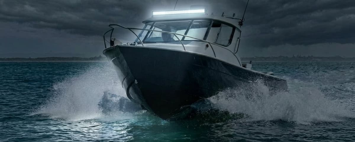 Barre LED étanche allumée sur bateau en navigation nocturne, faisceau puissant éclairant l'océan et les embruns